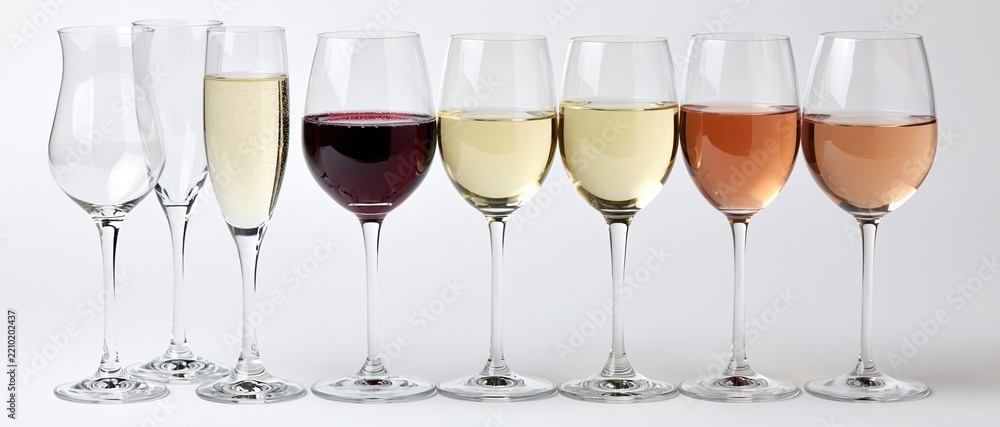 Obraz premium Seven wine and champagne glasses in a row filled with different colored wines against a white background