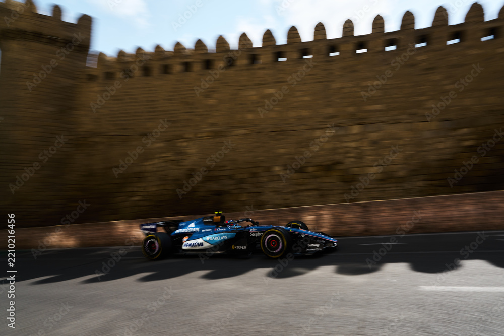 Obraz premium BAKU, AZERBAIJAN - SEPTEMBER 2026: Williams Racing F1 car speeds past the medieval stone walls of the Old City during the Formula 1 Azerbaijan Grand Prix 2026