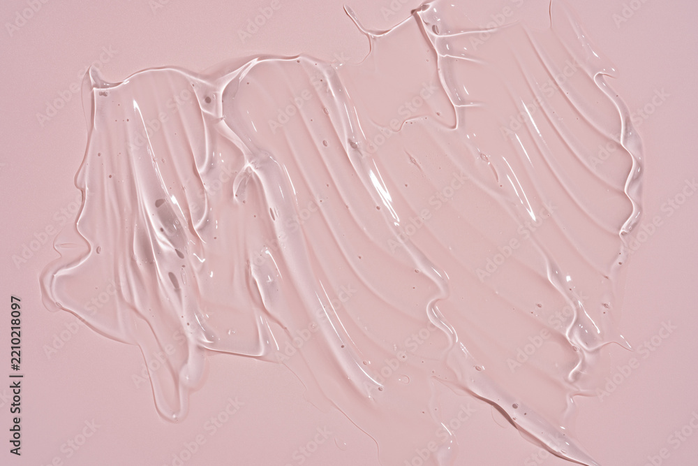 Fototapeta premium Transparent cosmetic gel texture smudge with air bubbles on pink background