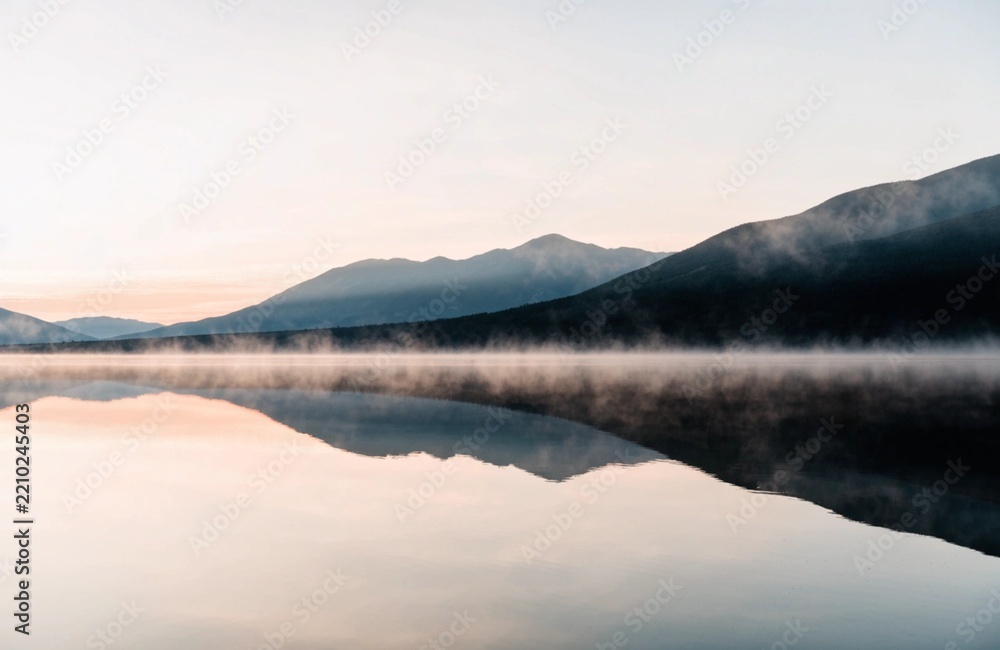 Fototapeta premium 薄霧が漂う湖と山並みの静かな水鏡風景