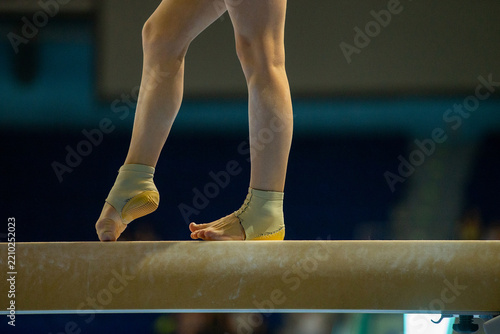 Close up female gymnast feet on balance beam during gymnastics competition