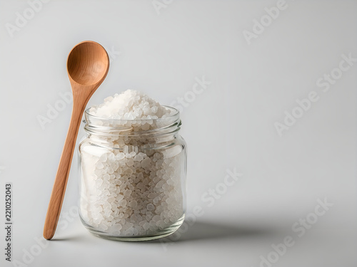 Sea salt in a glass jar with a wooden spoon