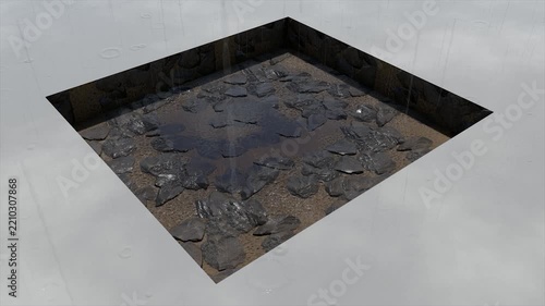 Rain falling on rough broken rocks and muddy ground in a pit