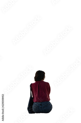 A dark-haired woman is sitting with her back turned, looking out for someone on transparent background.