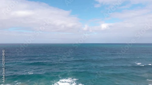 Aerial revealing view of rocky coastline and ocean waves crashing ashore, Fuerteventura, Canary Islands, Spain, Europe. Scenic view over the blue ocean revealing rugged rocks and cliffs on the shoreli
