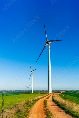 wind power plant concept of wind turbine close up and blue sky on background. Wind turbine producing green alternative energy for ecology and environment