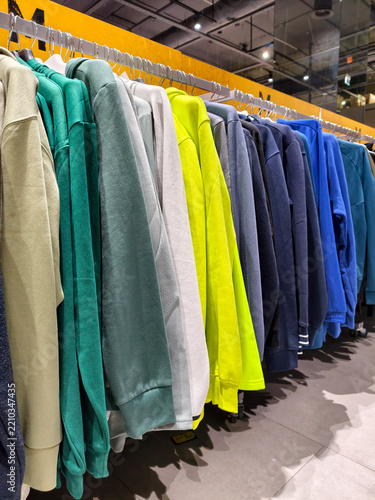 Bright outerwear collection hanging in a sporting goods environment presents a clean and colorful display of modern apparel