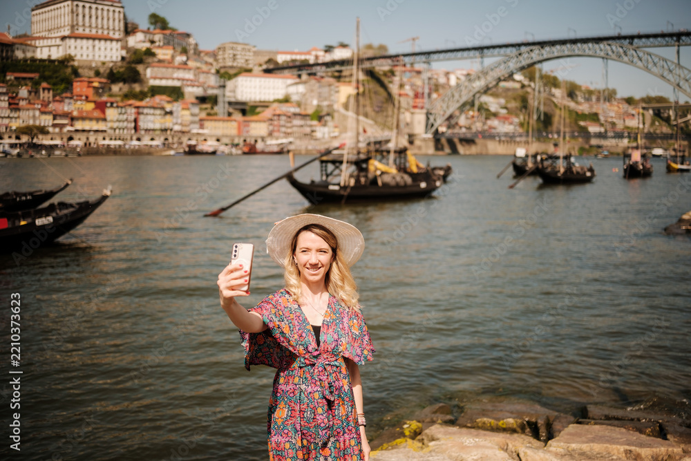 Fototapeta premium Woman taking selfie on douro riverfront in porto