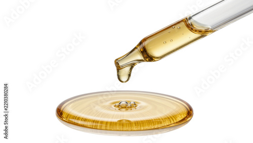 Glass dropper releasing golden liquid forming ripples on surface, isolated on transparent background