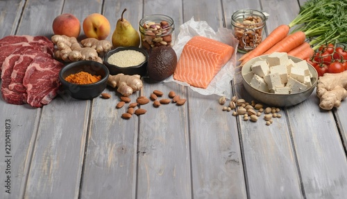 Variety of healthy ingredients and salmon on wooden table.