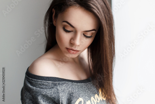 Fotografie Cute beautiful woman in a fashionable shirt looked down
