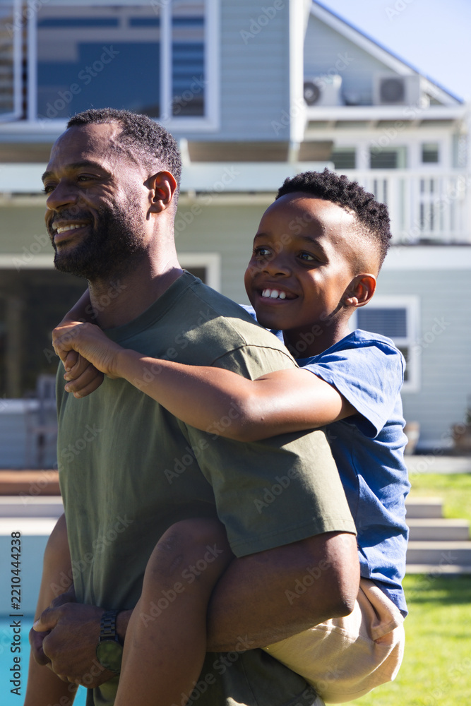 Obraz premium African American father and child playing, father wearing olive T-shirt carrying boy by pool edge
