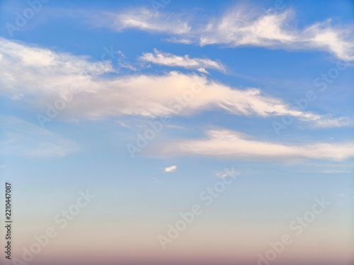Bright blue sky with soft white cumulus clouds, natural daylight, and copy space