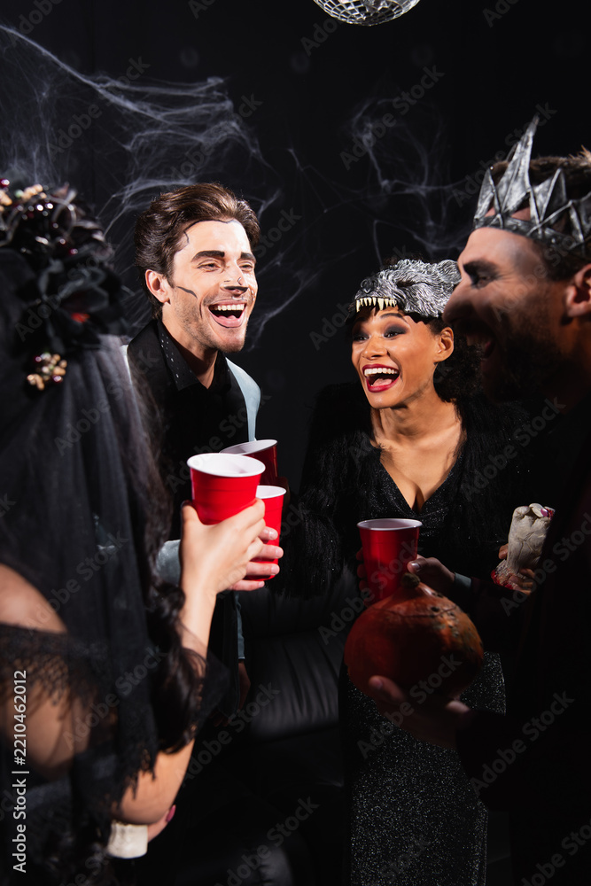 Obraz premium Multicultural friends joyfully celebrate Halloween at a spooky party