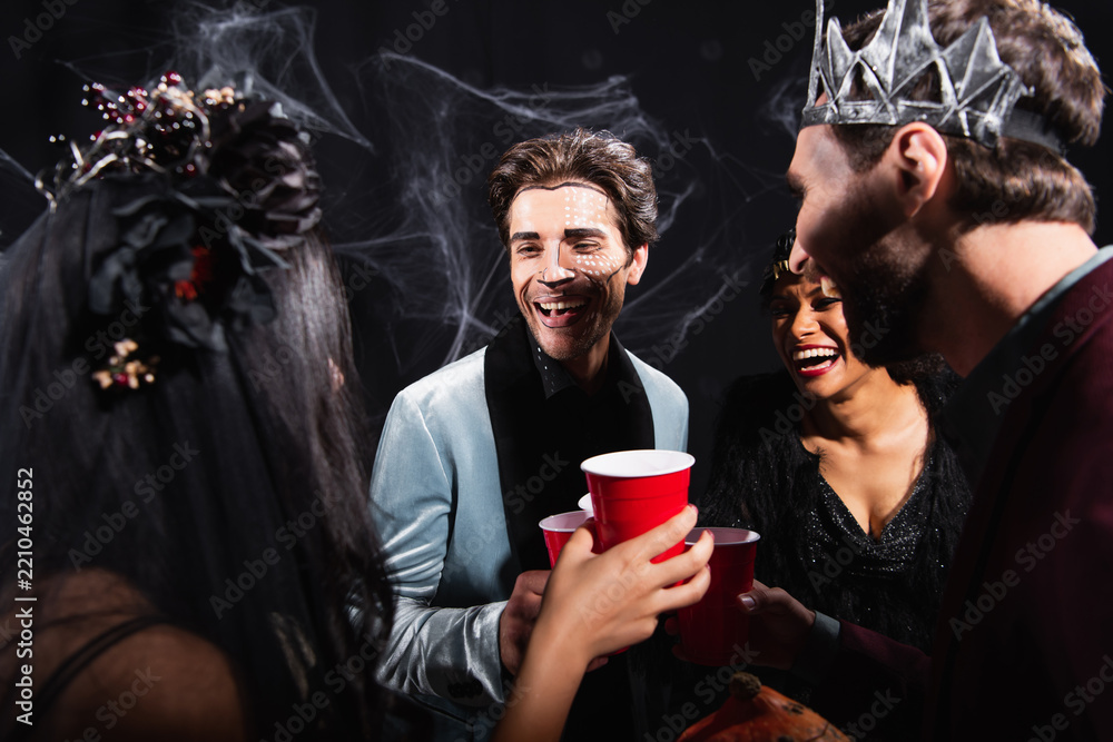 Obraz premium Multicultural friends celebrate Halloween with costumes and laughter