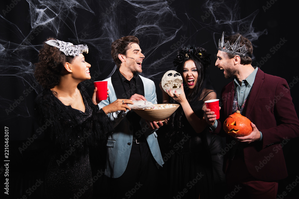 Obraz premium Multicultural friends in costumes enjoy a Halloween party filled with laughter