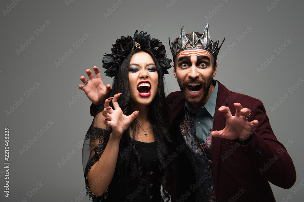 Obraz premium Spooky diverse couple in creative costumes share fear at a lively Halloween party