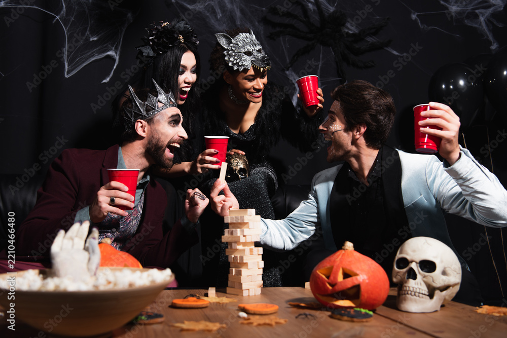 Obraz premium Multicultural friends celebrate Halloween with costumes and laughter at a party