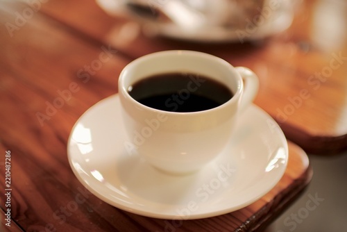Obraz na płótnie 木のテーブルに置かれた白いカップのブラックコーヒー｜カフェのイメージ
