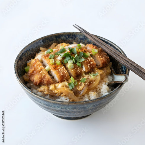 Japanese katsudon rice bowl with crispy golden breaded tonkatsu pork cutlet simmered in savory broth with egg and onions served with chopsticks on rustic bowl isolated on clean white background