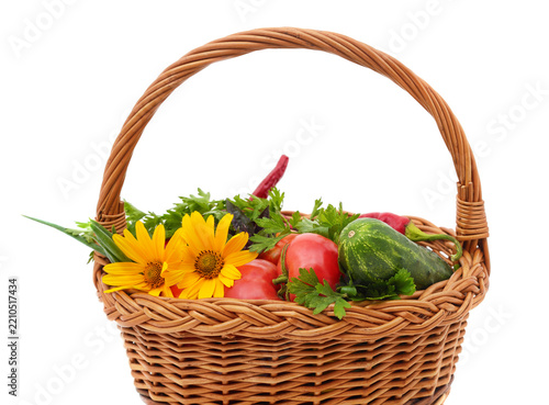 Fresh vegetables and flowers in wicker basket.