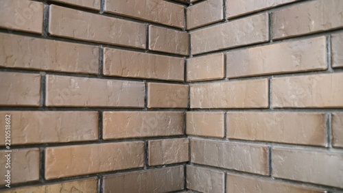 Close up perspective of brown brick wall corner with textured bricks and dark grey mortar joints, building facade and interior design