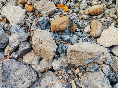 Close up view of abstract texture rough stone, rock and gravel rubble on the ground, showing crushed rock, coarse grit, natural texture and rugged detail use for background.