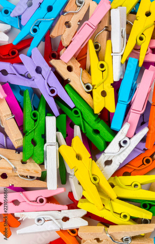 Multicoloured wooden clothes pegs on a white background.