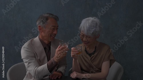 ウィスキーを飲むシニアの夫婦　黒背景