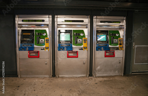 Row of MetroCard ticket vending machines inside a New York City subway station. Automated machines allow commuters to buy and refill transit cards for public transportation.