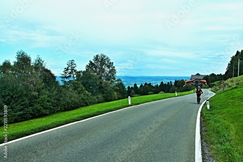 Austria - view on the cyclist on the road to the Burghof Sadlerin in Bregenzwald