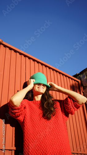 Woman playing hiding game wearing green beanie