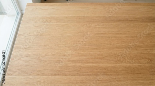 Top View of Light Oak Wooden Table Surface with Natural Wood Grain Texture Near Bright Window, Minimalist Interior Background