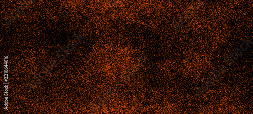 Abstract orange glitter dust and grunge noise texture background with black speckles