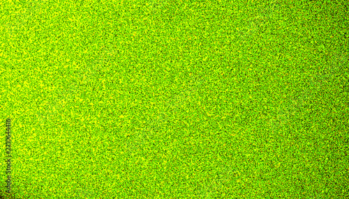 Neon lime green glitter texture background with fine sparkling grain and acid yellow stipple surface