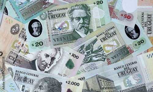 Uruguayan peso money bills in pile on table. Uruguay UYU currency banknotes background