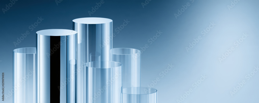 Obraz premium Transparent glass cylinder tubes with reflective surfaces arranged in varying heights on blue gradient background, creating modern and clean look
