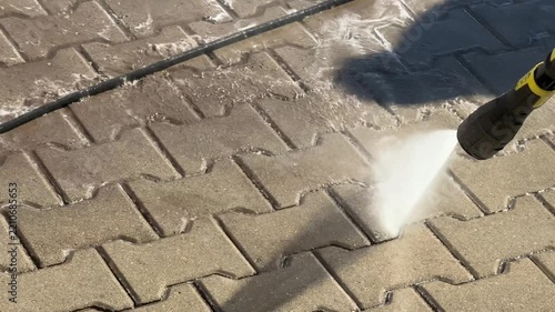 Pressure washer cleaning dirty paving stones