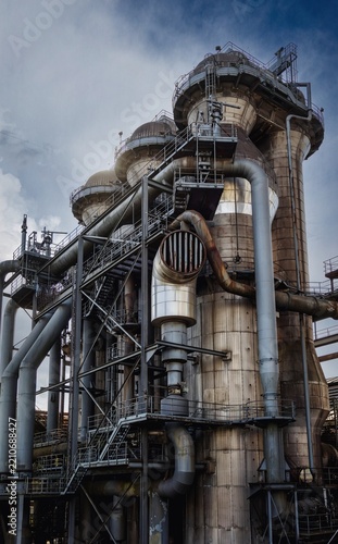 A close-up photograph of a historic and imposing blast furnace in a decommissioned industrial area.