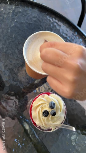 Overhead View of Hand Stirring Drink Beside Berry Dessert