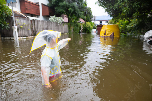 boy pointing at car that flooded in bangkok thailand, lifestyle of Thai people in massive flooding, Severe weather. 2026/09/27