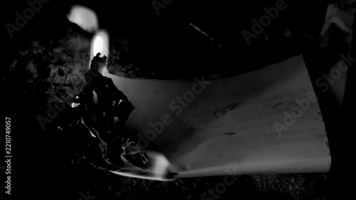 Burning paper document in darkness cinematic black white clip