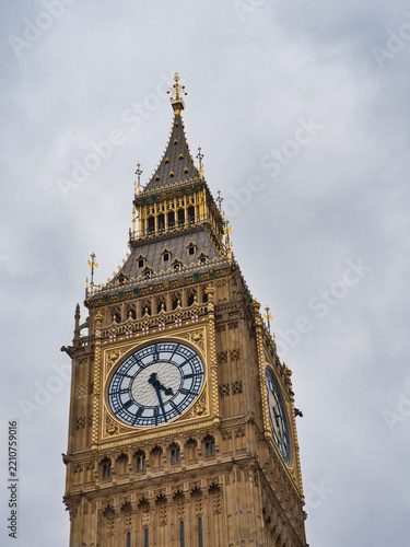Big Ben Clock Tower London - Close-up view of the iconic Big Ben clock tower against a dramatic cloudy sky in London, United Kingdom, showcasing its intricate details.