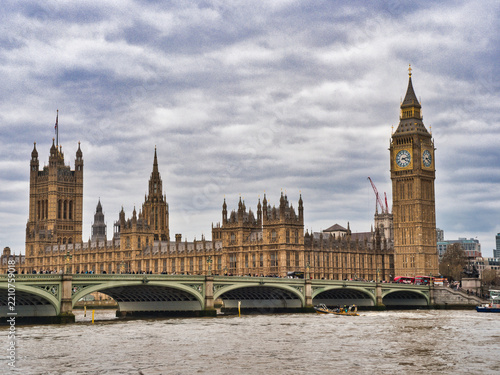 Houses of Parliament and Big Ben on Tham - Iconic London skyline featuring the historic Houses of Parliament and Big Ben clock tower, viewed across the River Thames under a cloudy sky