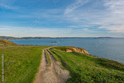 Coastal dirt path leads along the grassy cliffs of Bodega Head in Northern California