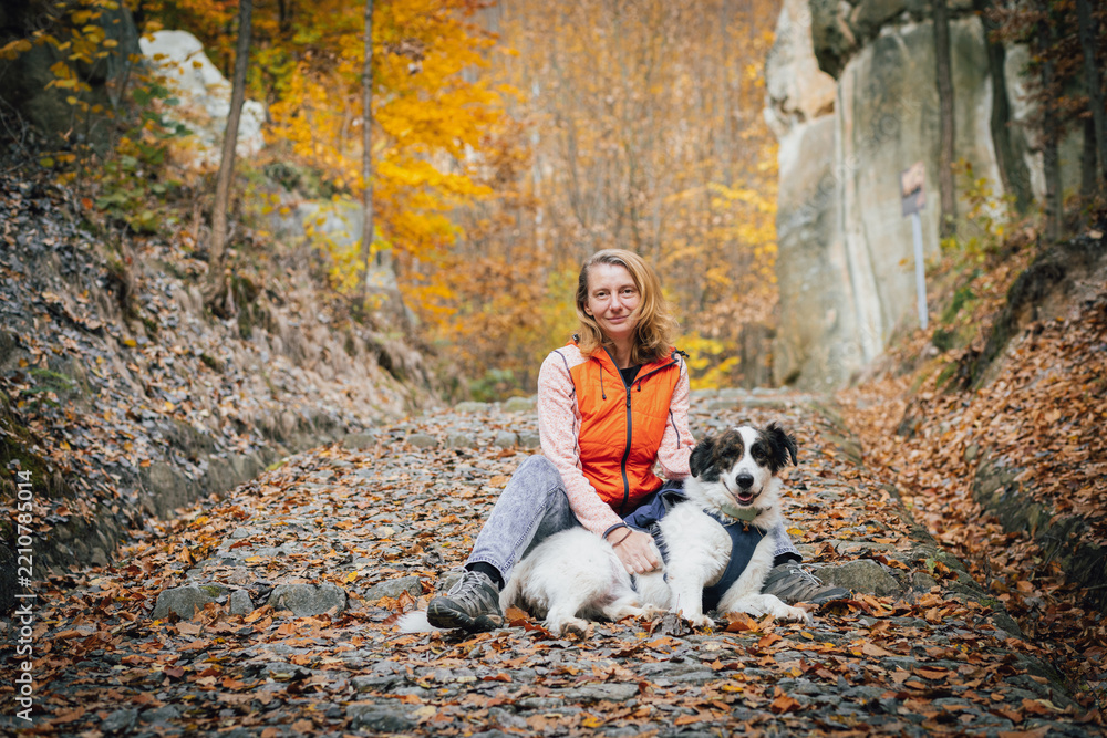 Obraz premium happy white dog with owner in autumn forest