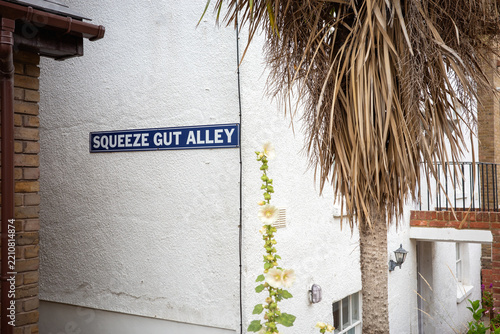 Squeeze Gut Alley, a quirky unusual street sign in Whitstable, Kent, UK