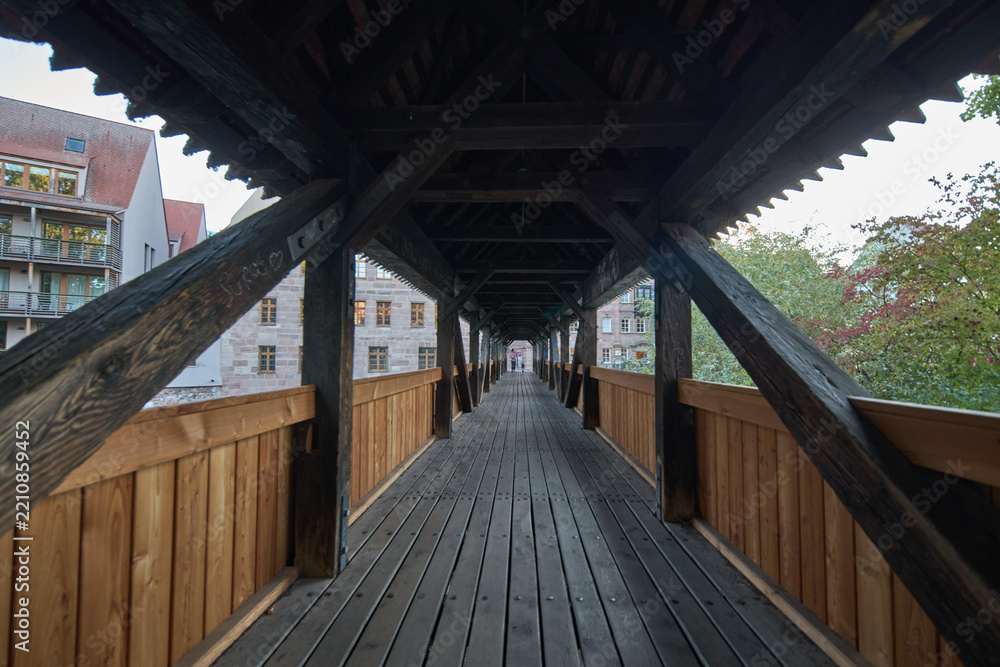 Fototapeta premium A scenic view through the interior of a historic wooden covered bridge in a European city setting