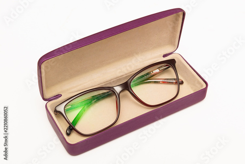 A modern pair of women's eyeglasses inside an open hard shell case.