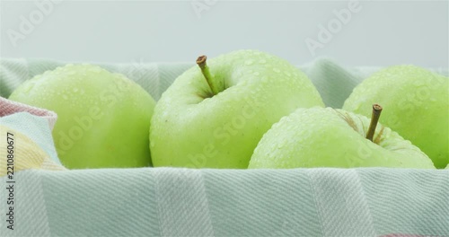 Bright and juicy green summer apples. Fresh and bright green apples in a colourful kitchen towel. Cultivation of apples and apple farming. Home apple orchard.
